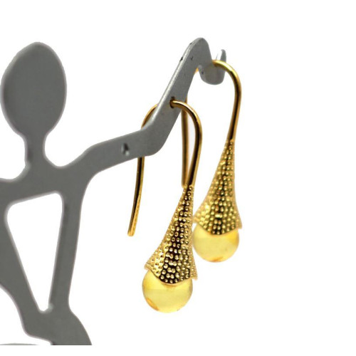 Gold-colored earrings with a honey-colored polished amber ball