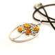 Oval shaped pendant with pieces of Baltic amber